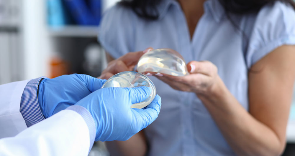 Surgeon and patient holding salines for breast augmentation surgery