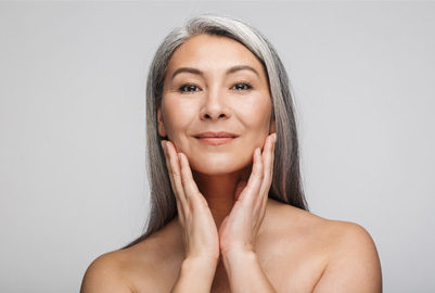 Senior woman smiling touching her face